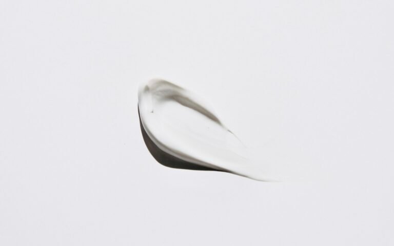 Smear of white cosmetic cream on a plain background