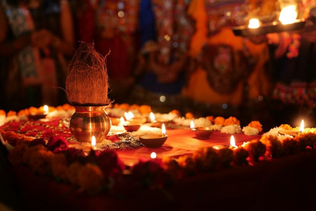 Kalash with coconut surrounded by lit diyas and marigolds