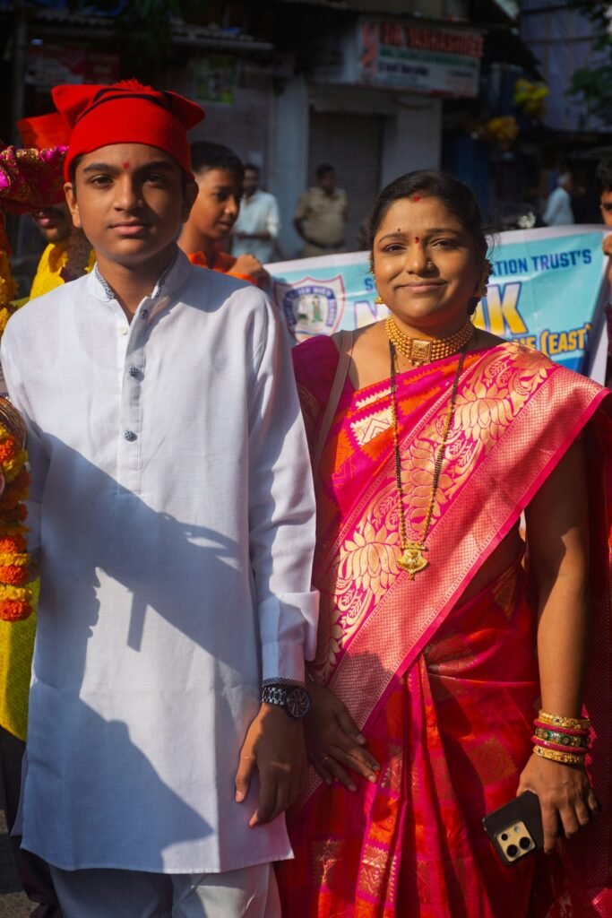 Diwali Outfits for the Whole Family Under ₹5,000 (2026) Mother in a red silk saree and son in a white kurta at a festival