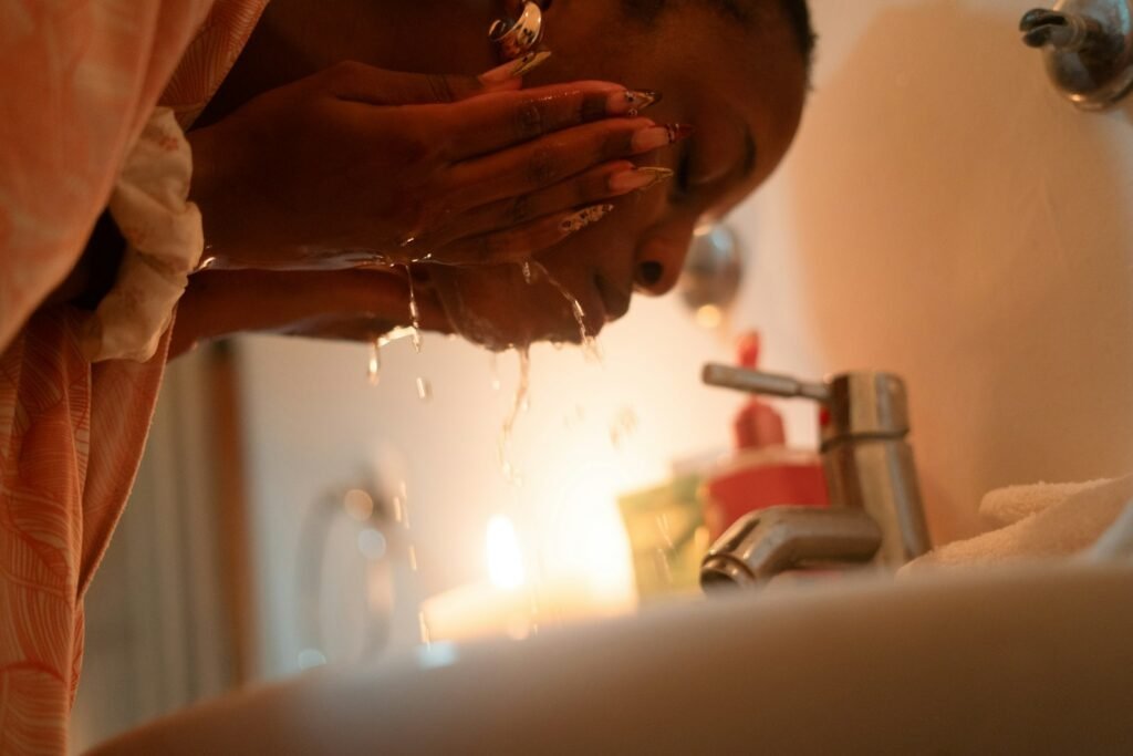 Best Cleanser for Sensitive Skin in India (2026): 6 Gentle Picks Woman gently washing her face at a bathroom sink
