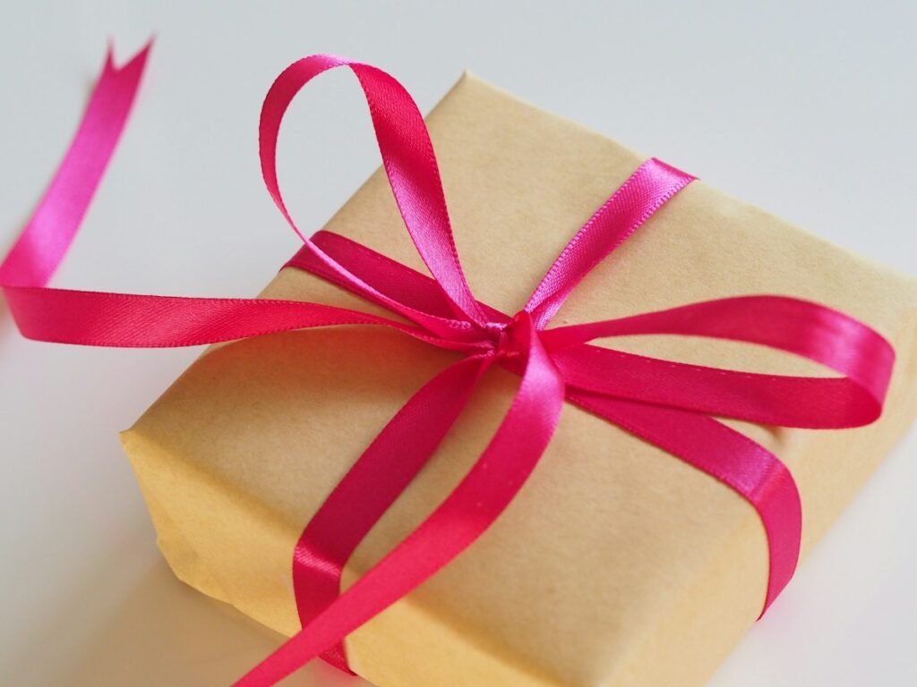 Gift box wrapped in kraft paper with a pink ribbon
