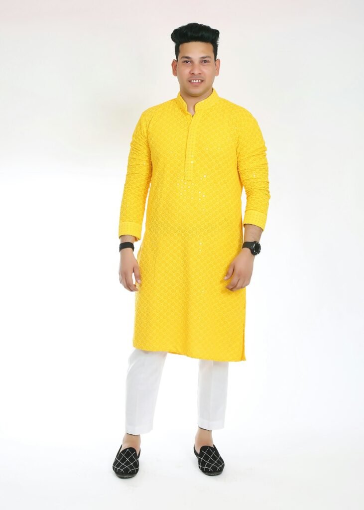 8 Best Diwali Kurtas for Men Under ₹1,000 (2026) Man in a yellow kurta with white pyjama and black mojaris