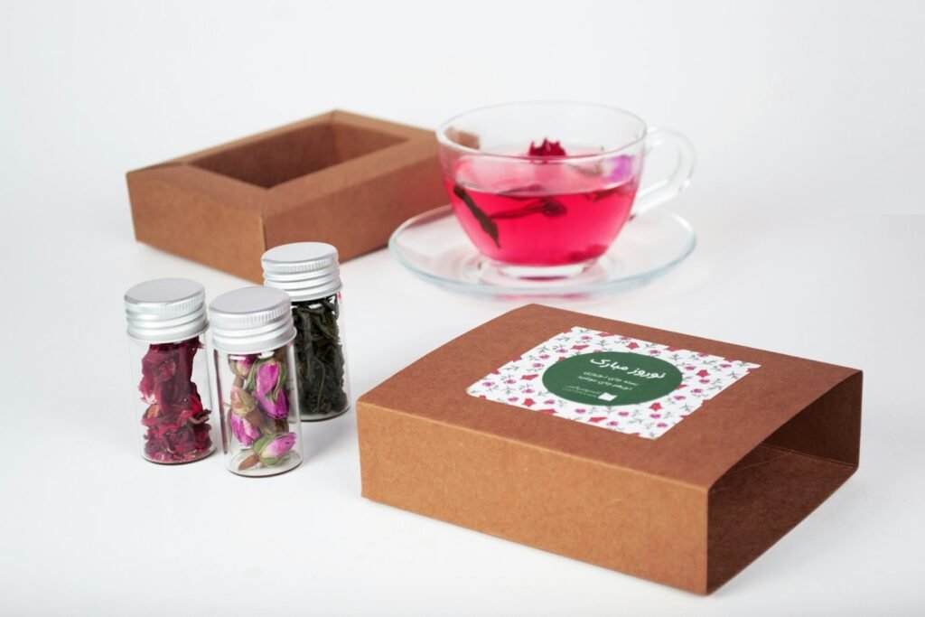 10 Premium Corporate Diwali Gifts for Employees, Clients and Boss (2026) Tea gift box with jars of loose-leaf tea and a glass cup of rose tea