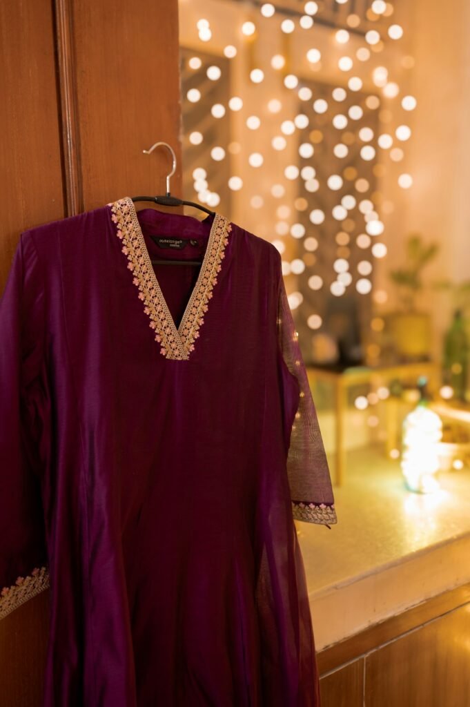 8 Diwali Kurta Sets for Women Under ₹1,500 (2026) Embroidered maroon festive kurta hanging against Diwali lights